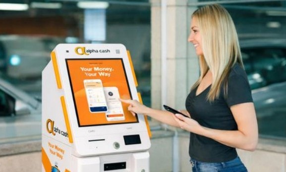 Woman using an Alpha Cash kiosk to access financial services